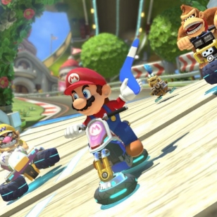 Mario Kart 8 kurvailee trailereilla ja sateenkaaritien kuvilla